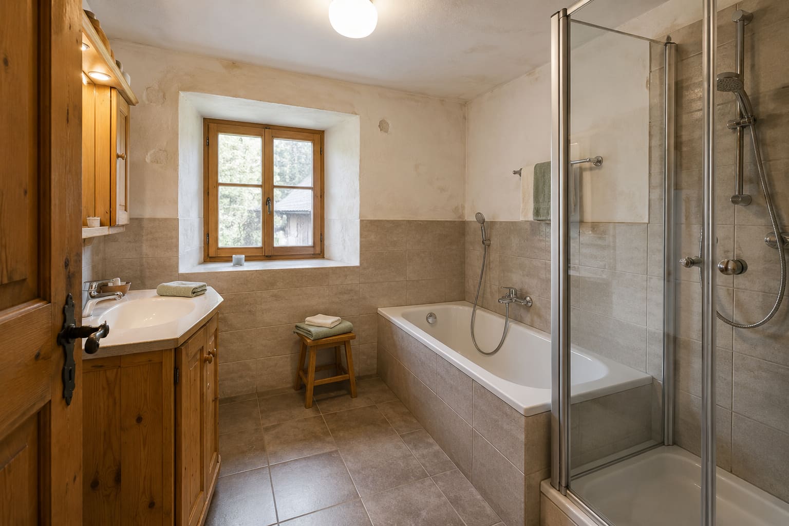 Bad der Ferienwohnung Bergkristall mit Badewanne, separater Dusche und Holzwaschtisch
