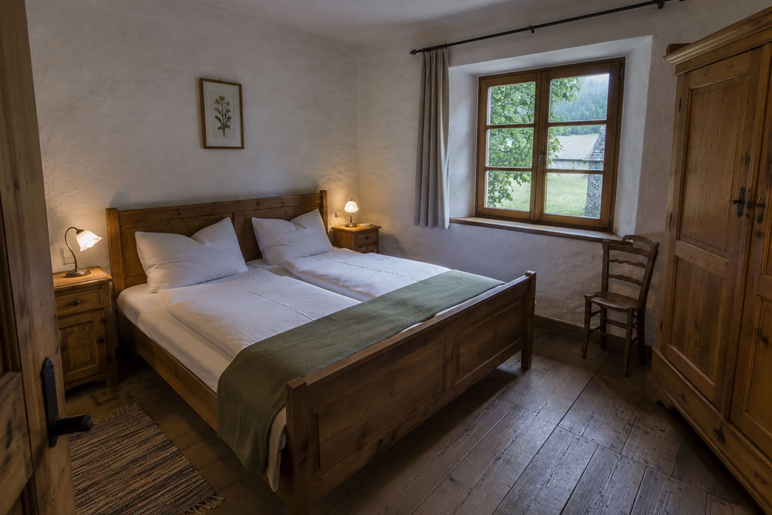 Schlafzimmer der Ferienwohnung Bergkristall mit Zirbenbett, Nachtkästchen und Bauernschrank