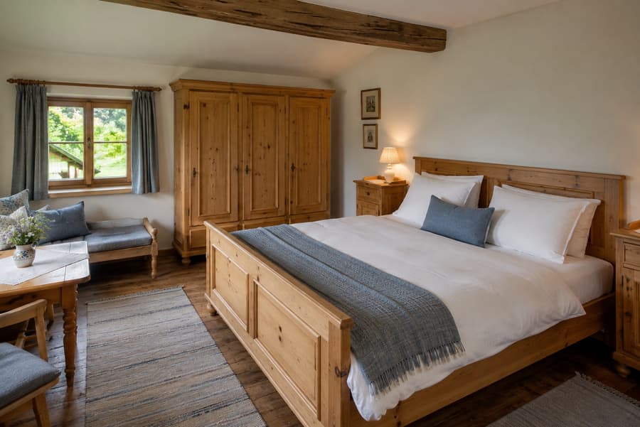 Doppelzimmer Enzian mit Zirbenbett, Fensterbank, kleinem Tisch für zwei und Blick ins Grüne